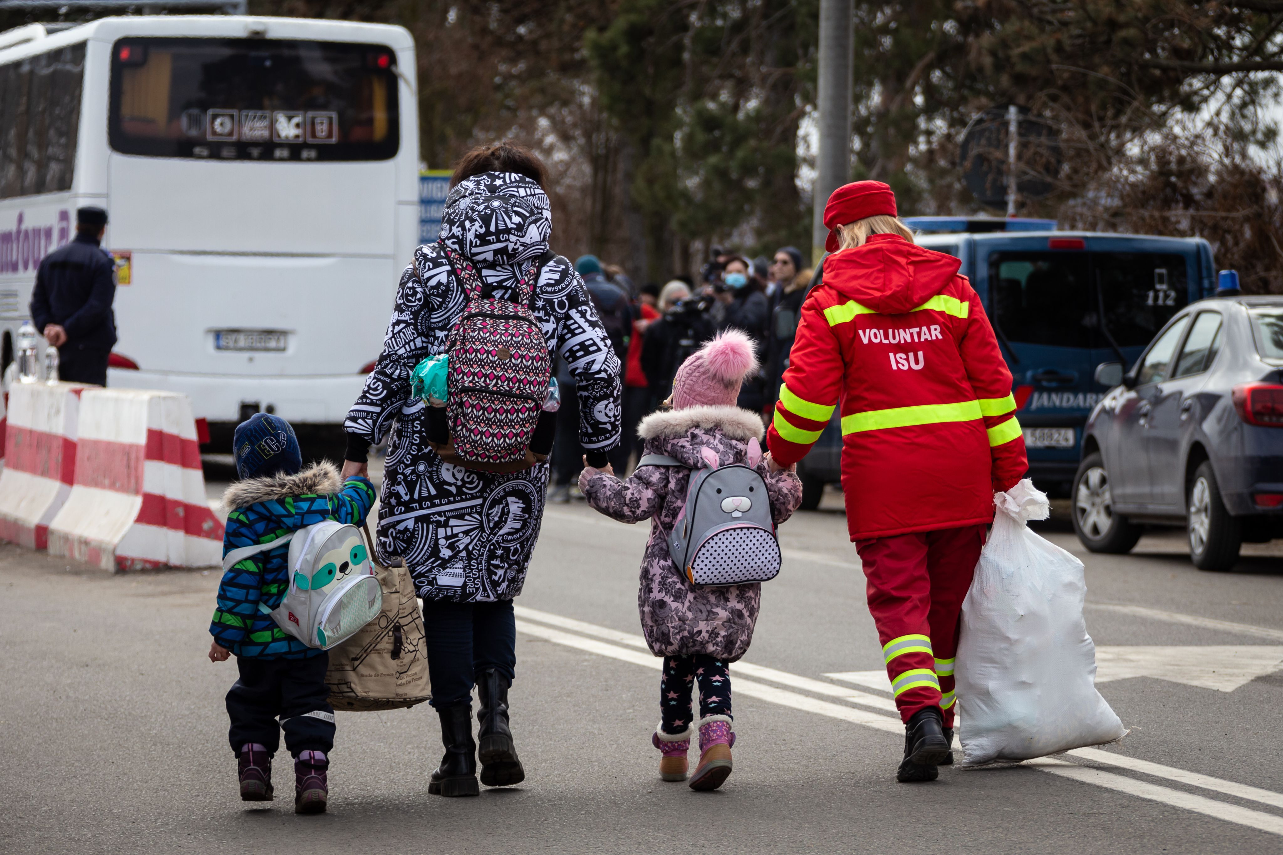 Ukrainian families and children crossing the border into Romania to escape conflict.