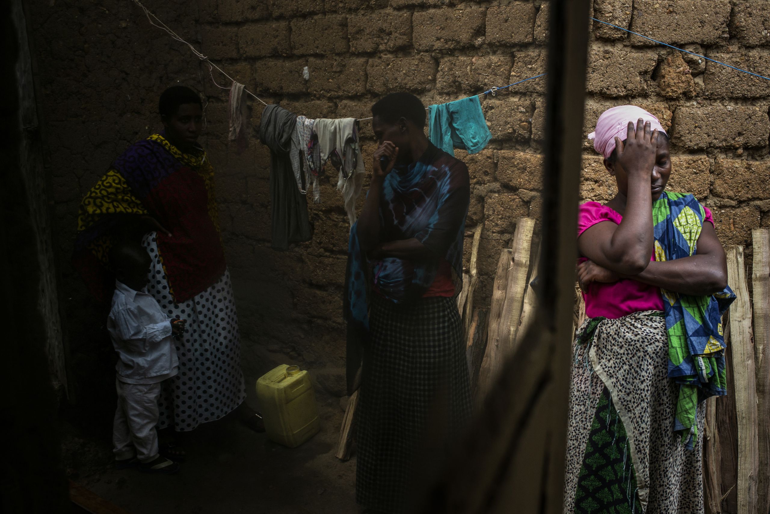 Vanessa Ntakirutimana gets emotional while her neighbours and sister visit her inside her home.